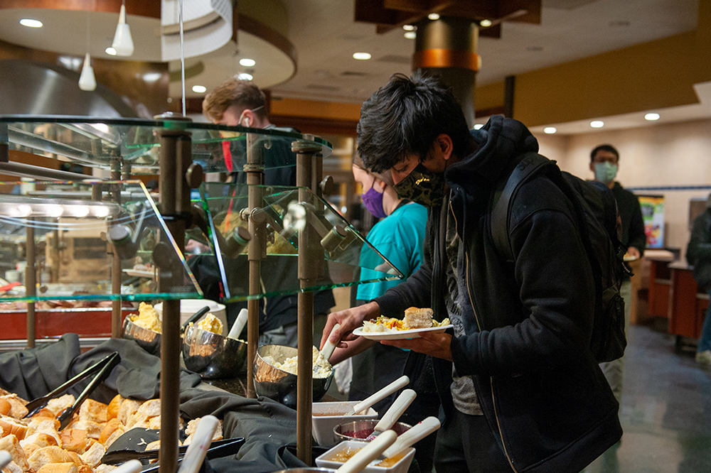 A student fills their plate at Ford Dining Court.