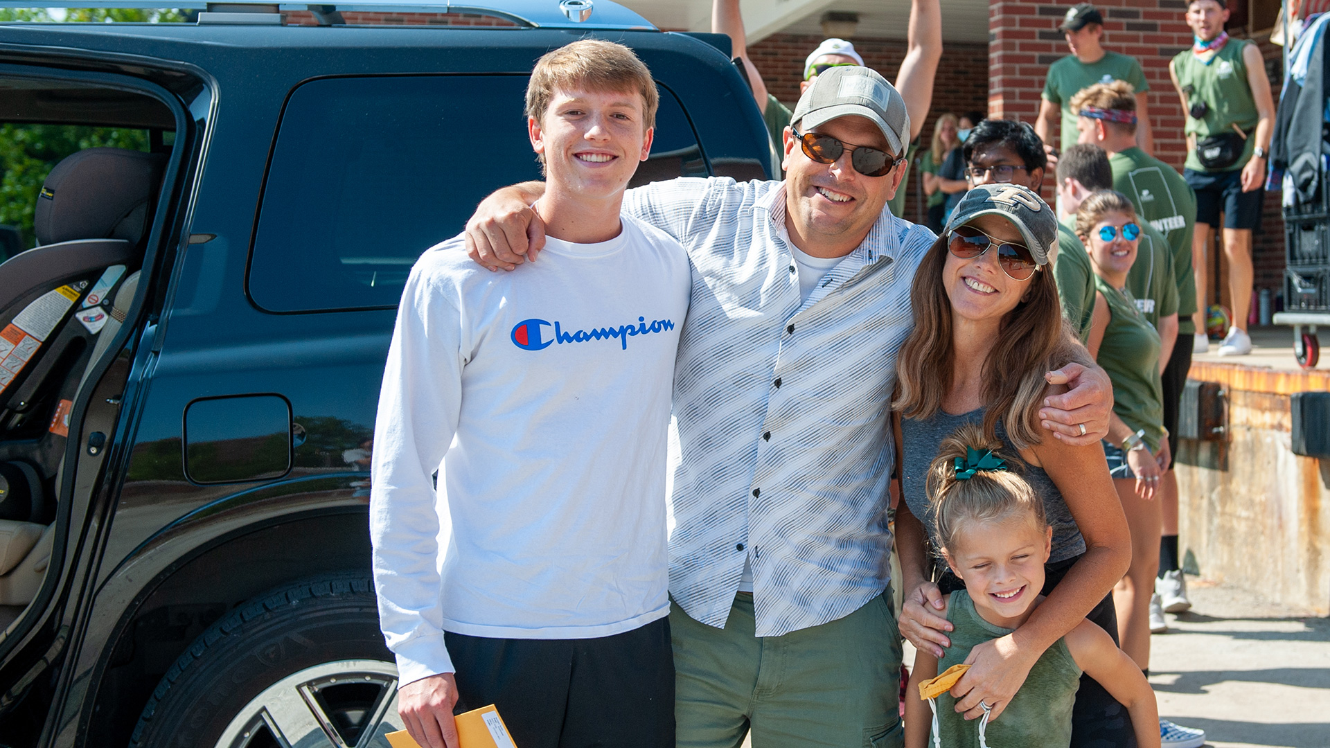 A Purdue family posing for a photo outside of a residence hall on move-in day.